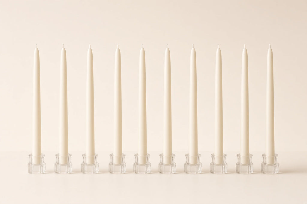 Row of ivory taper dinner candles in glass holders