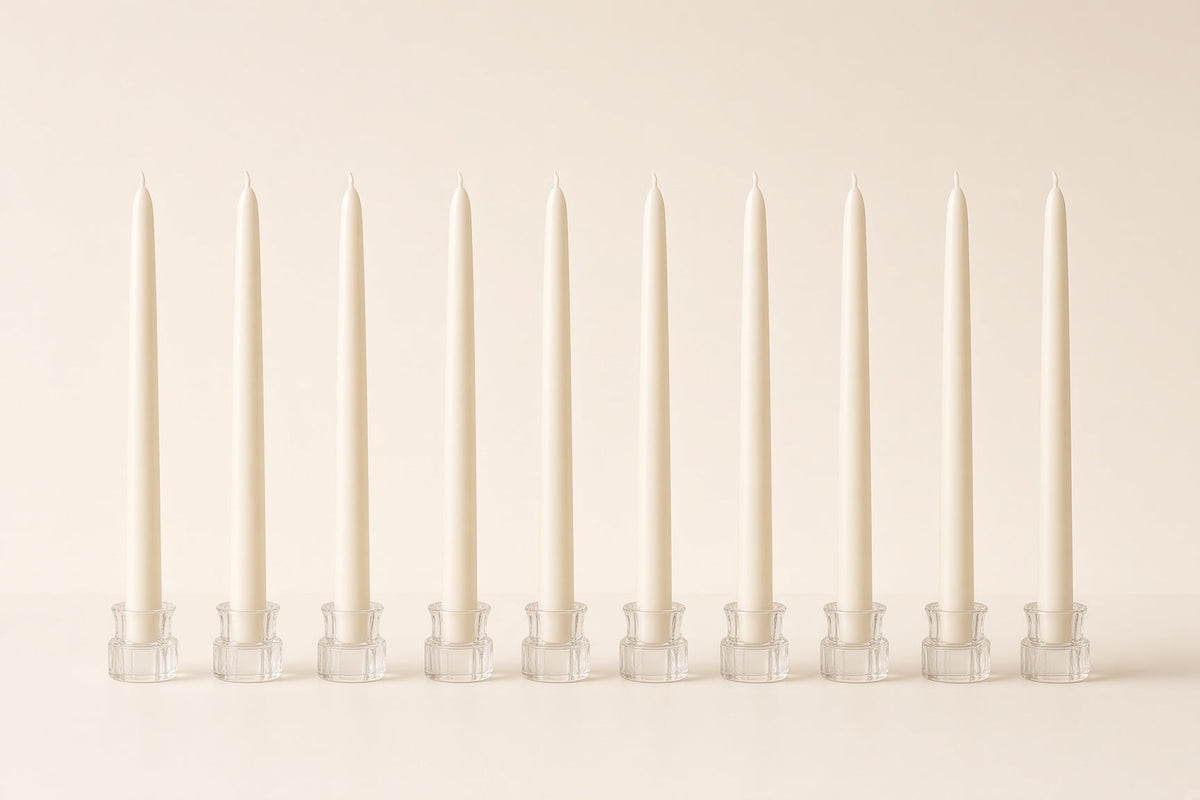 Row of ivory taper dinner candles in glass holders