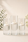 White floating candles lit in glass cylinder vases