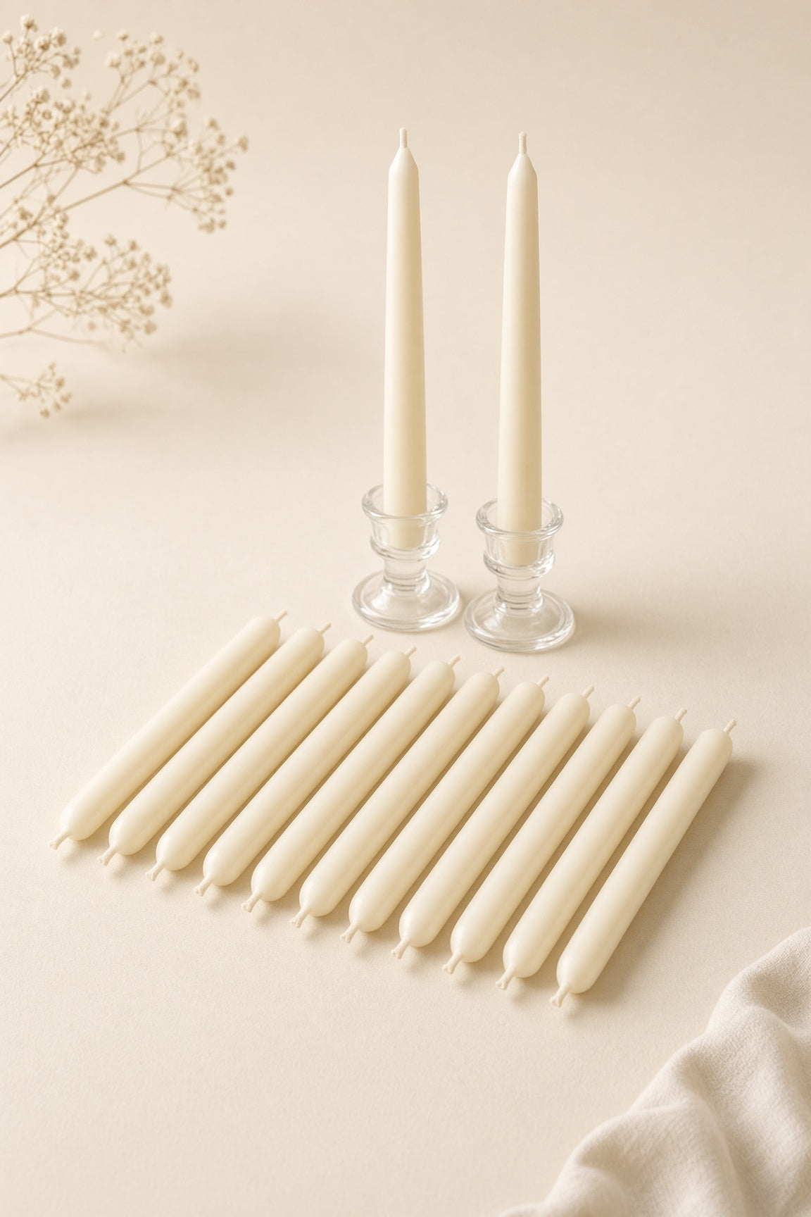 Dozen ivory taper candles laid flat with two in holders