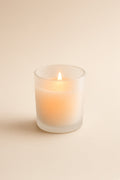 Frosted glass votive candle glowing softly